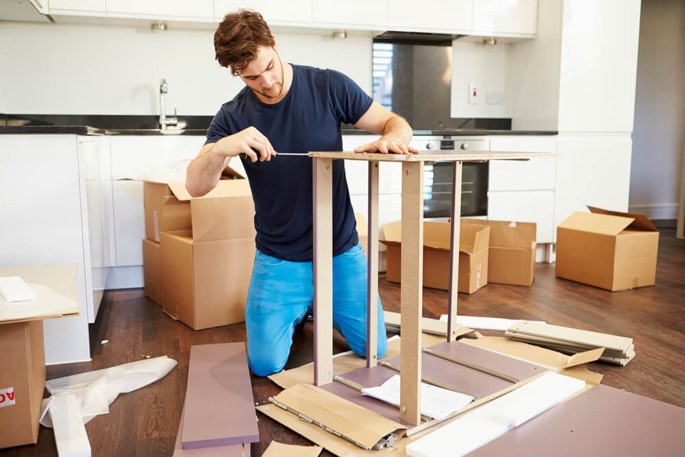 young male assembling some flat packed kitchen items