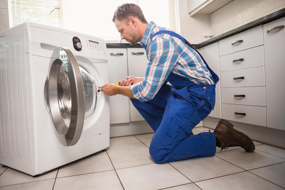 image of handyman repairing a broken washing machine